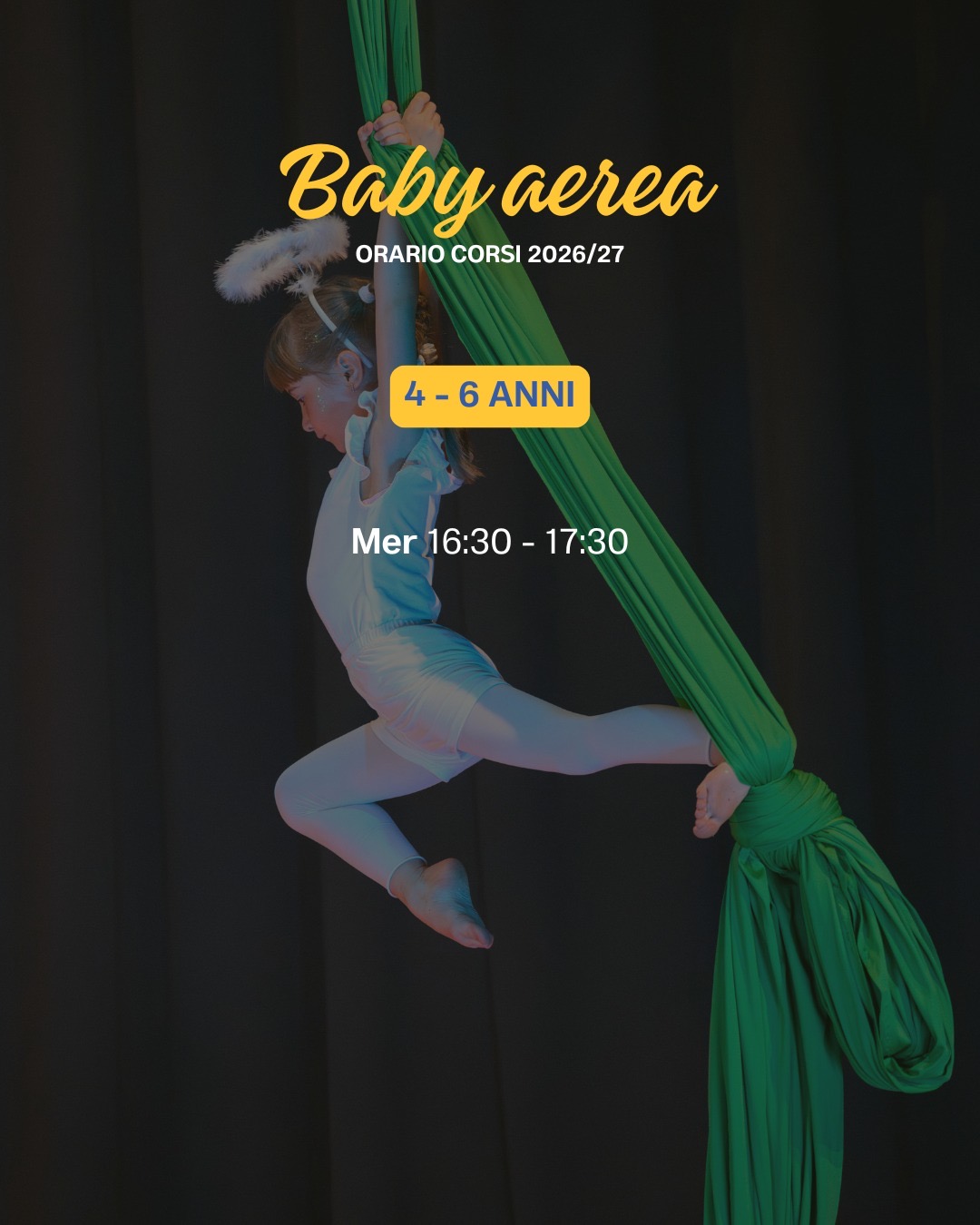 Bambina sospesa su un tessuto aereo verde durante lo spettacolo